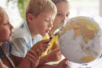 Children using magnifying glass in Geography