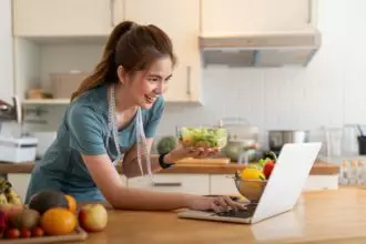 Young woman eat healthy food sitting in the kitchen